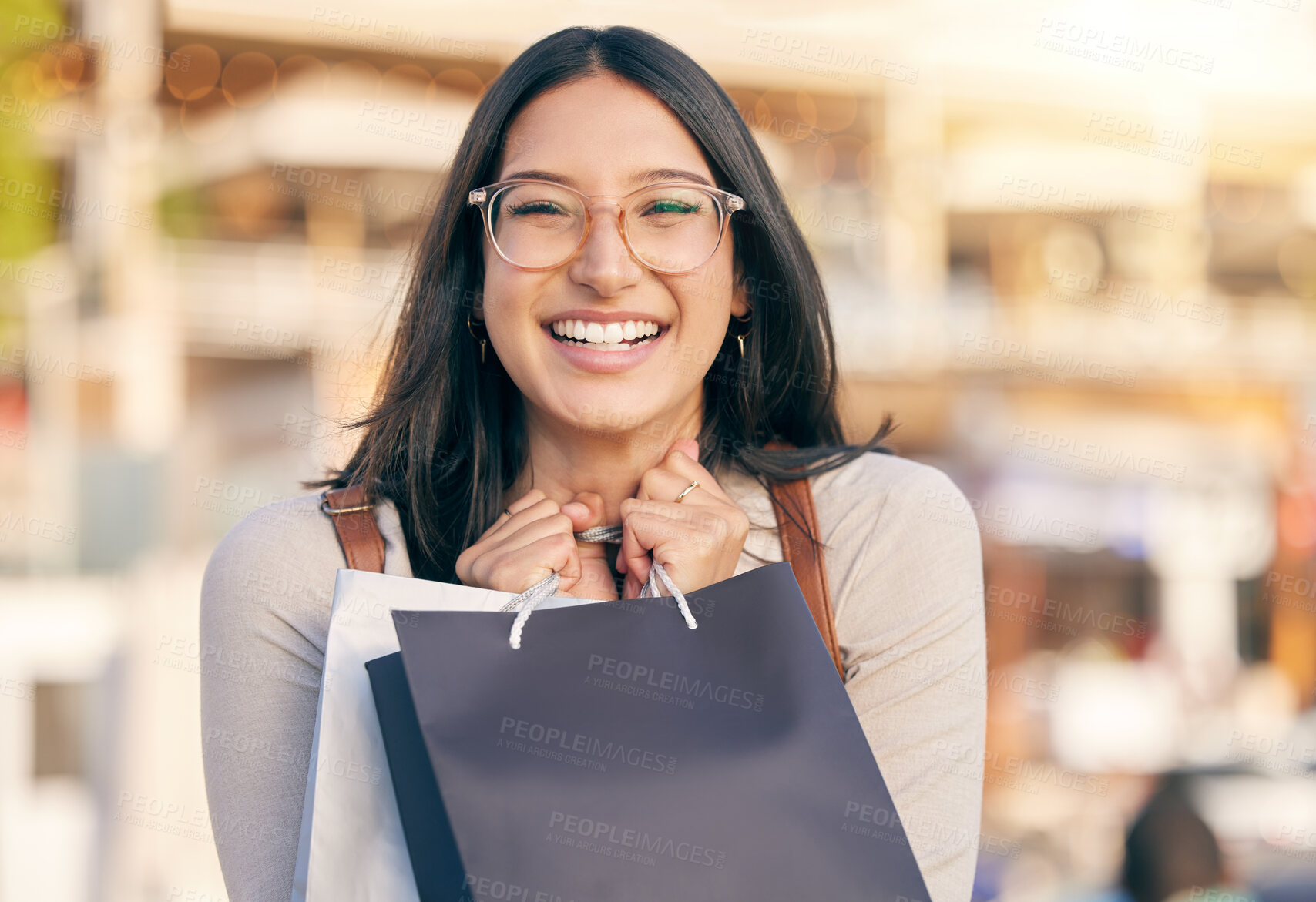 Buy stock photo Portrait of an attractive young woman walking alone outside while shopping in the city