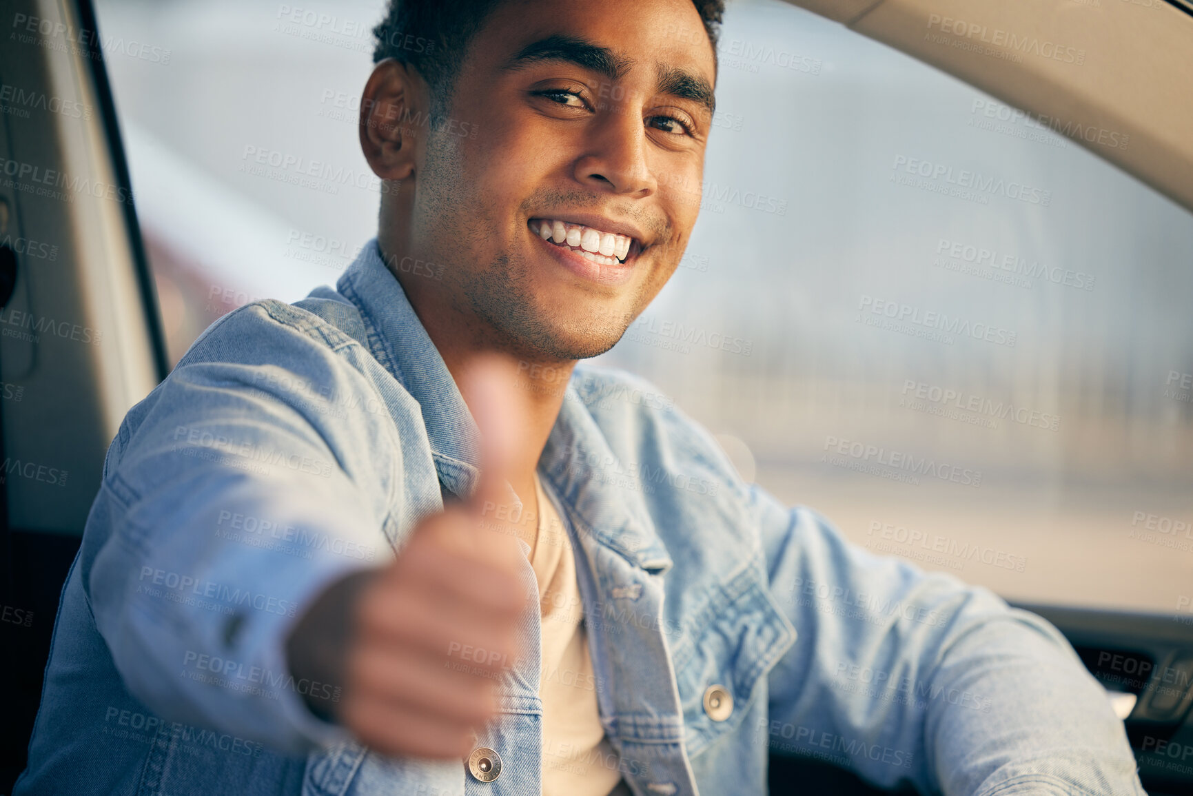 Buy stock photo Shot of a young man showing thumbs up while traveling in a car