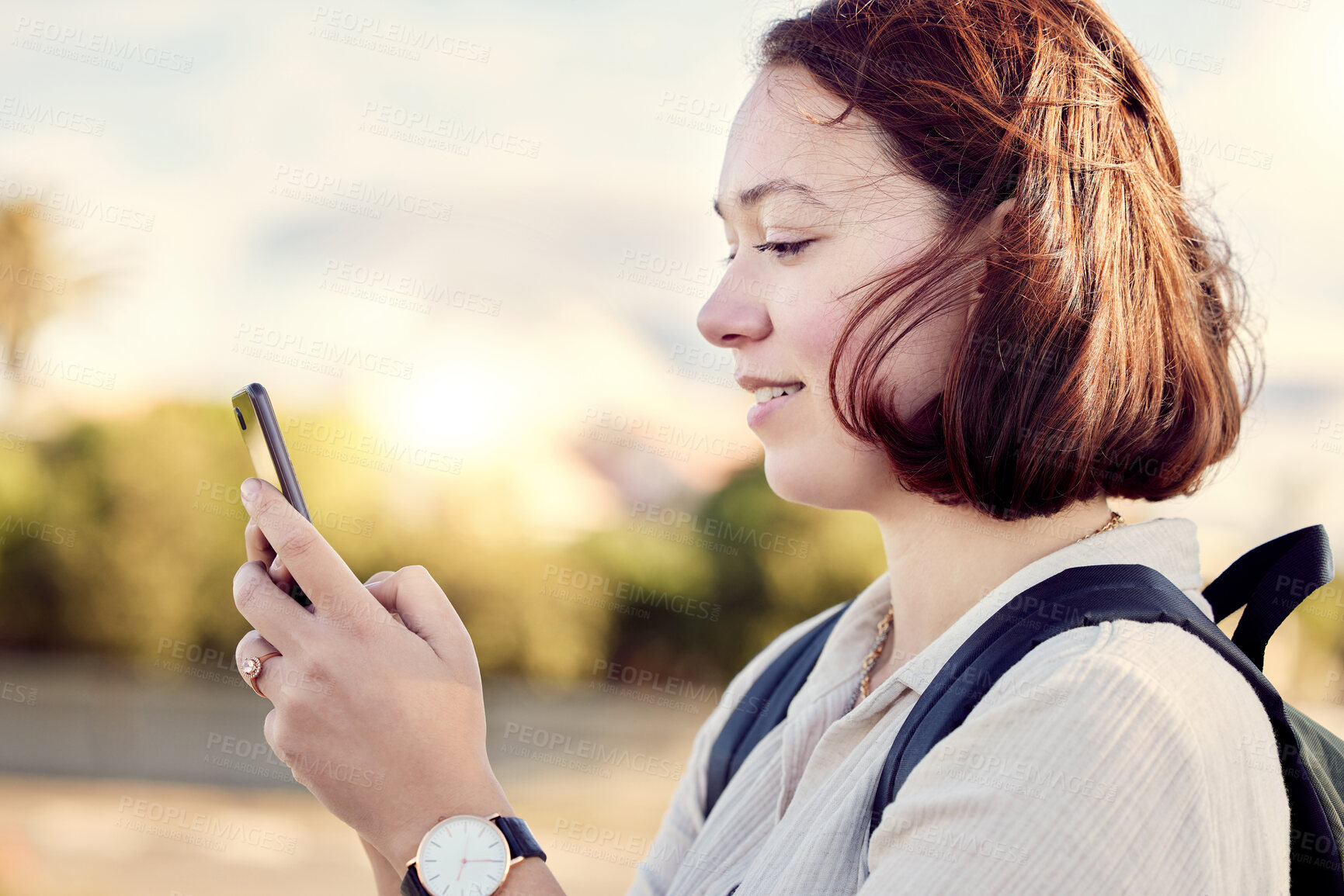 Buy stock photo Shot of a woman using her cellphone while standing outside