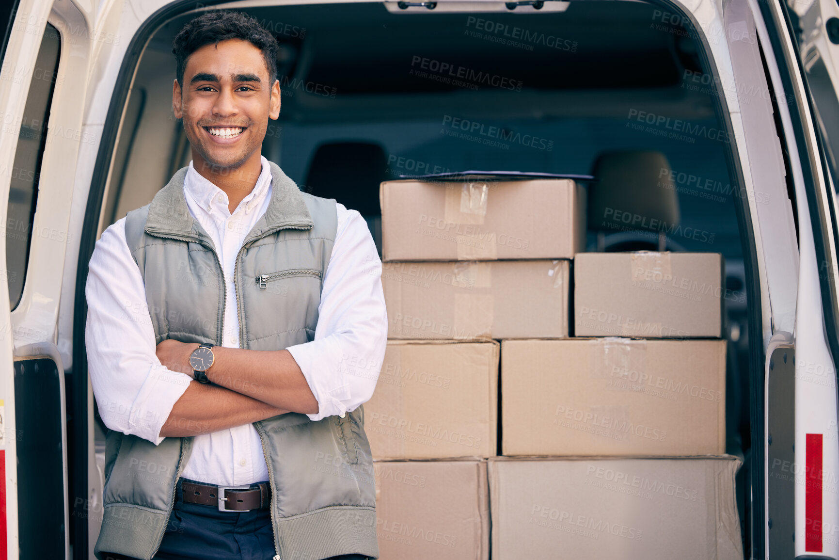 Buy stock photo Shot of a delivery man standing with his arms crossed by a delivery van stacked with boxes