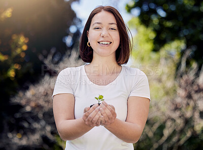 Buy stock photo Shot of a young woman holding a plant growing out of soil