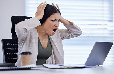 Buy stock photo Shot of a young businesswoman looking angry while using a laptop in a modern office