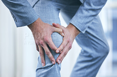 Buy stock photo Cropped shot of a businessman holding his knee in pain