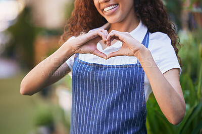 Buy stock photo Shot of a female business owner forming a heart with her fingers in her nursery