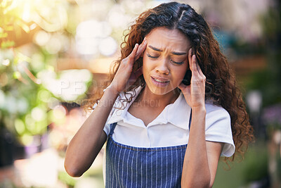 Buy stock photo Shot of a young female nursery owner experiencing a headache at work