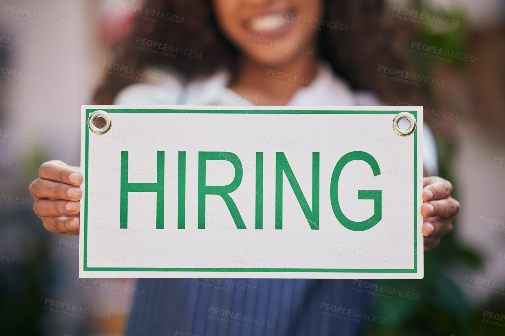 Buy stock photo Shot of a business owner holding a sign stating that she's hiring