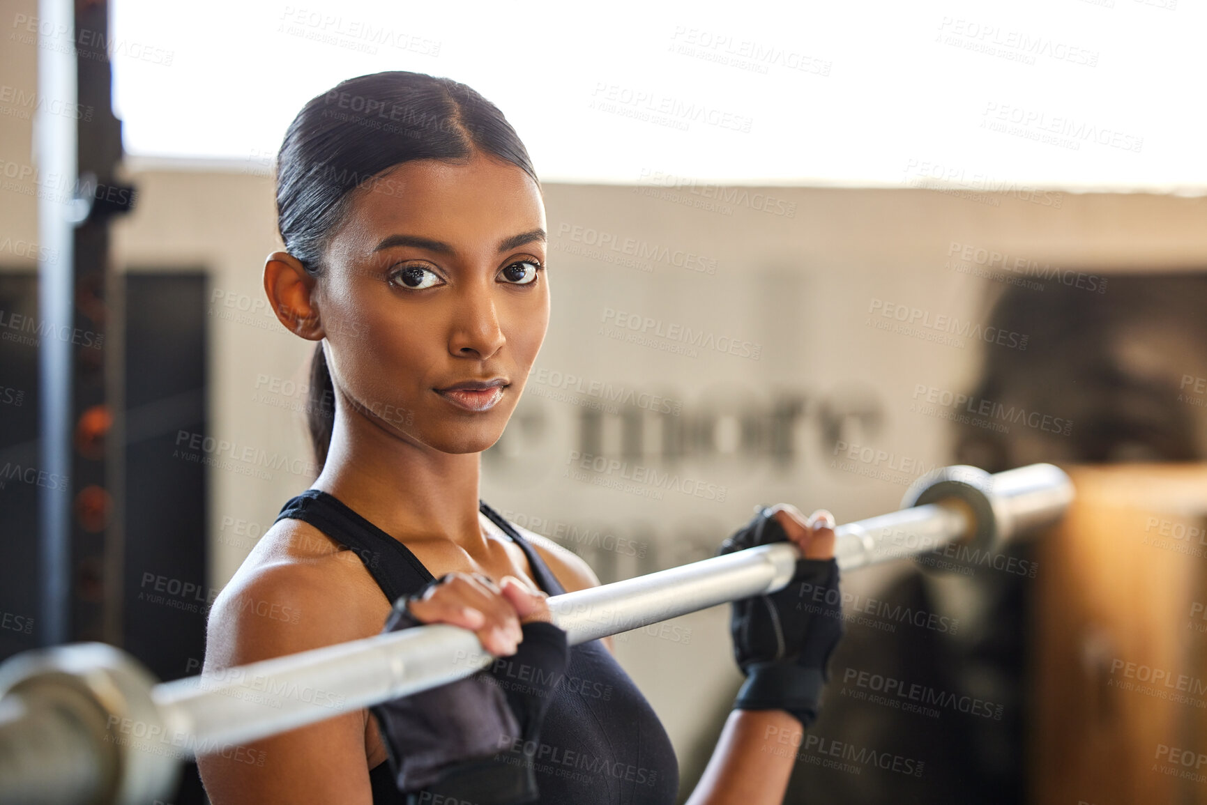 Buy stock photo Portrait, Indian woman or bodybuilder with barbell in fitness training, workout or exercise for body building. Strong girl, mindset or healthy athlete weightlifting powerlifting with focus at gym 