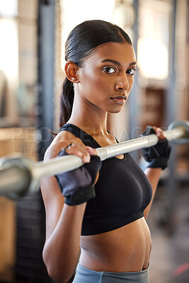Buy stock photo Shot of a young woman working out with weights in a gym
