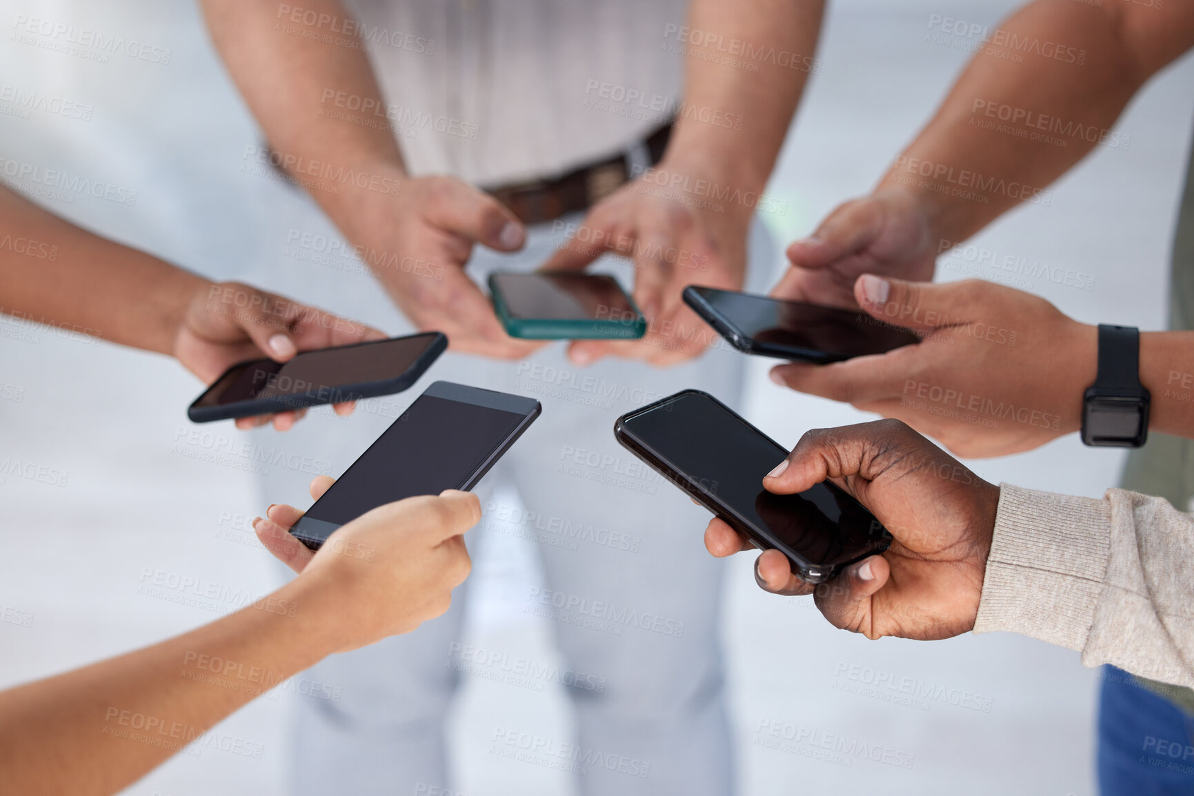 Buy stock photo Closeup shot of a group of businesspeople using their cellphones in synchronicity in an office