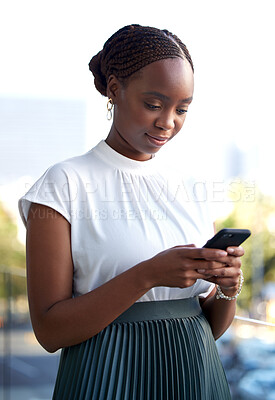 Buy stock photo Shot of a young businesswoman using her smartphone while taking a break on her office balcony