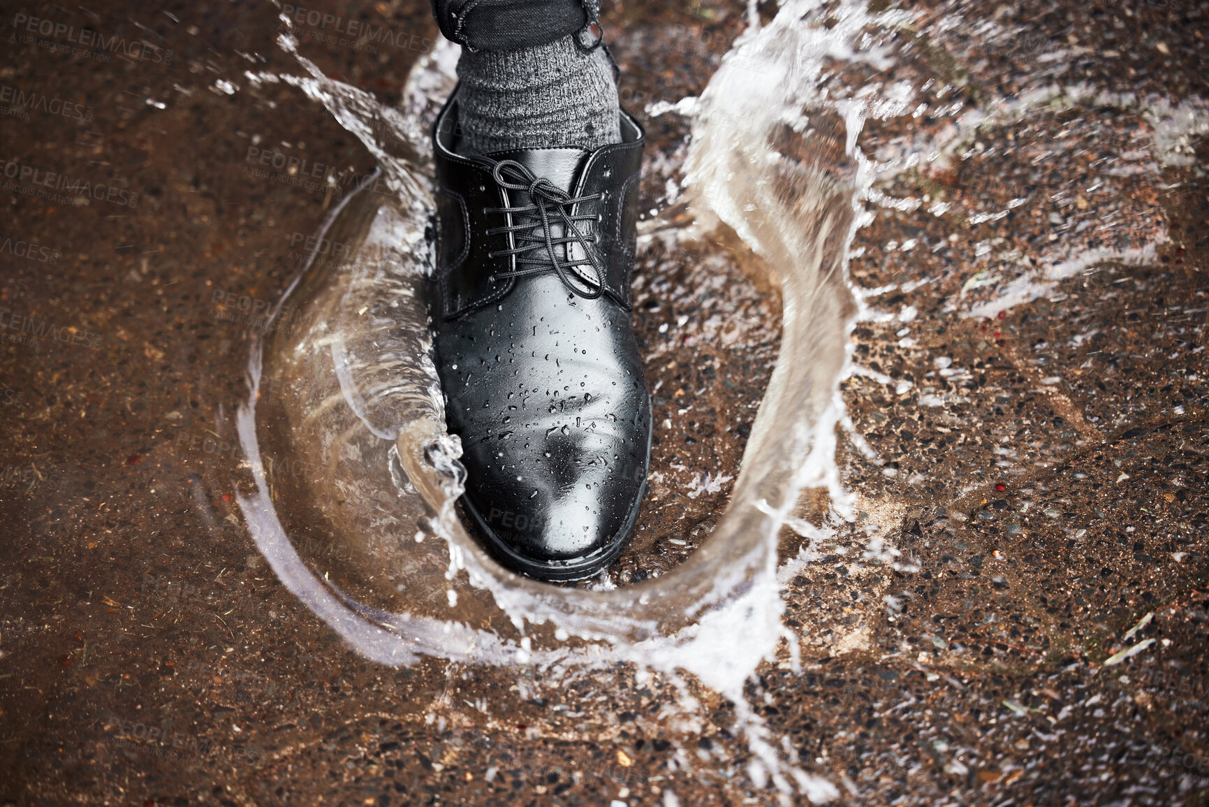 Buy stock photo Shot of a unrecognizable man walking in a puddle of water outside