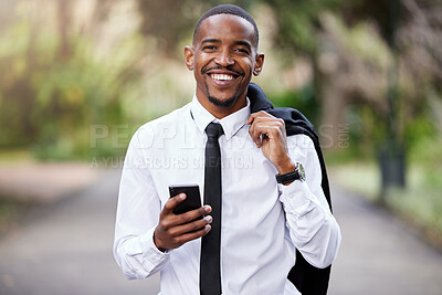 Buy stock photo Shot of a young businessman using a phone in the city