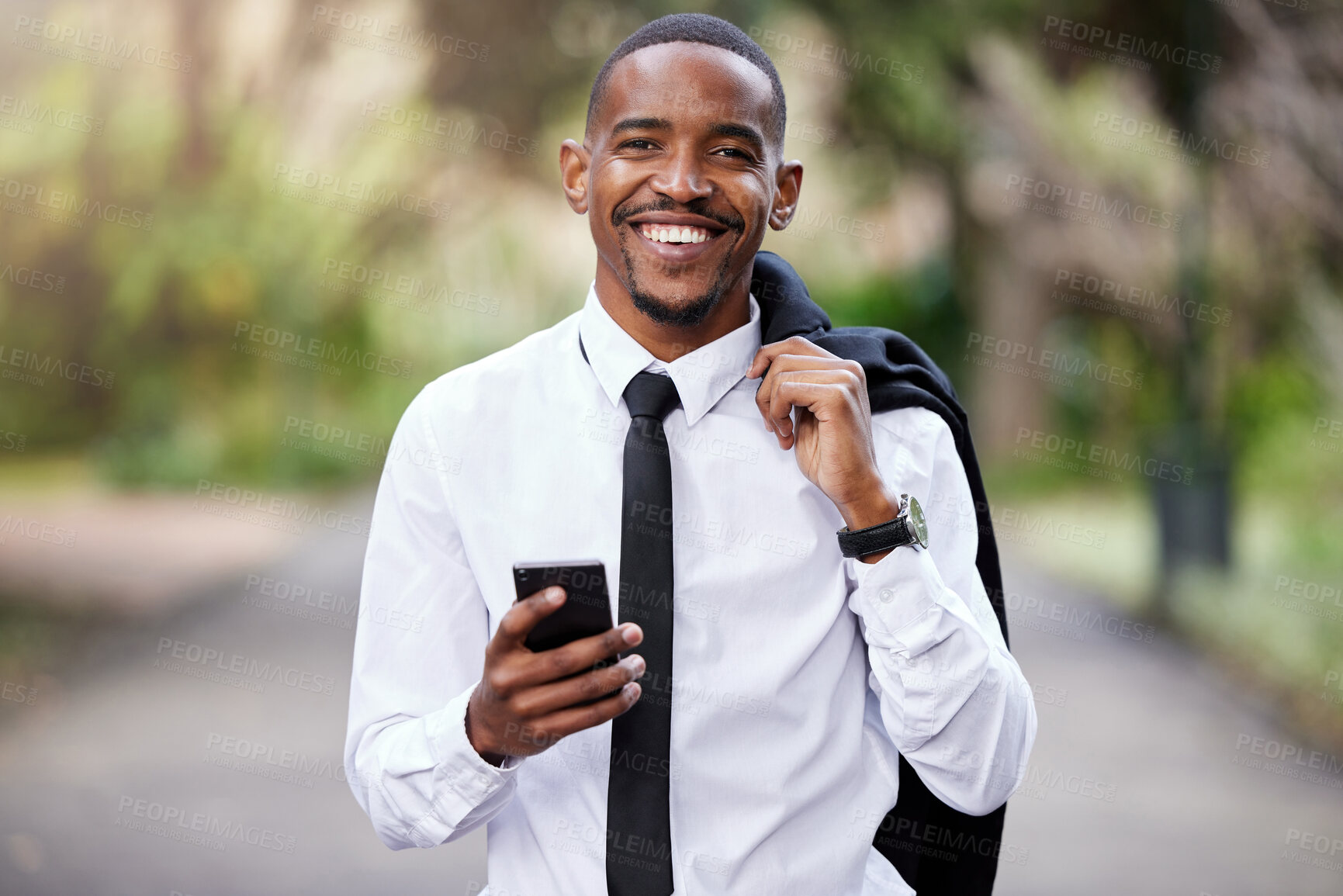 Buy stock photo Shot of a young businessman using a phone in the city