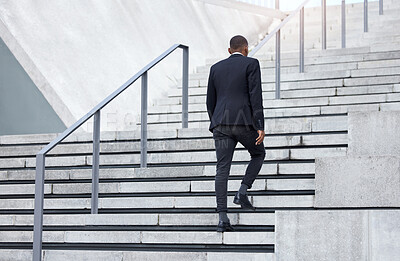 Buy stock photo Shot of an unrecognizable businessman walking up stairs in the city