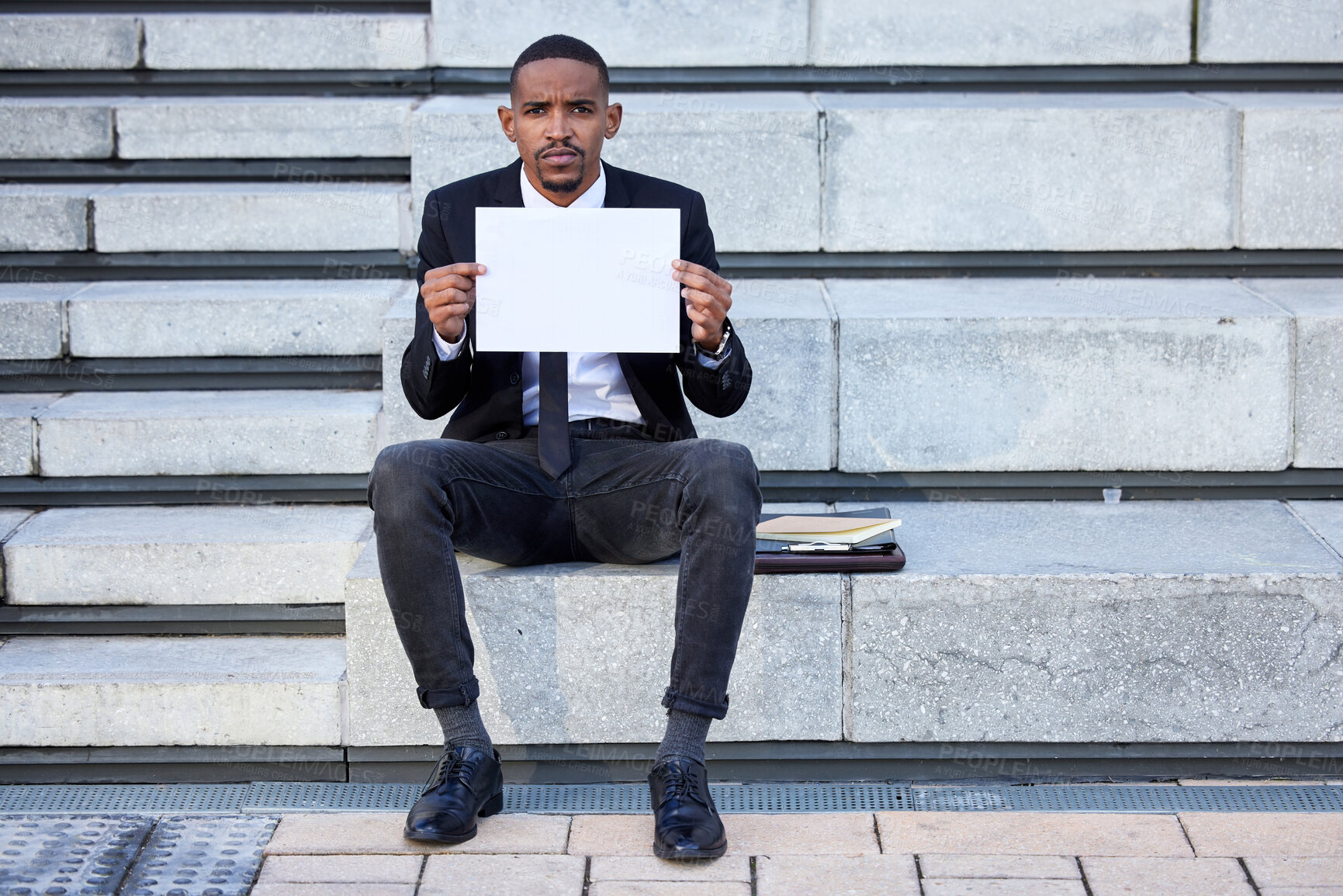 Buy stock photo Shot of a young businessman holding a sign in the city