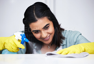 Buy stock photo Indian woman, smile or cleaner with spray bottle for table, kitchen counter or dirty furniture in home. Happy, maid or janitor washing messy surface with product, liquid soap or cloth with gloves