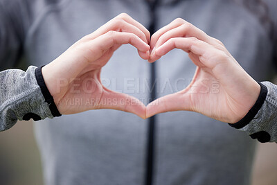 Buy stock photo Shot of a woman forming a heart shape with her hands while out for a run