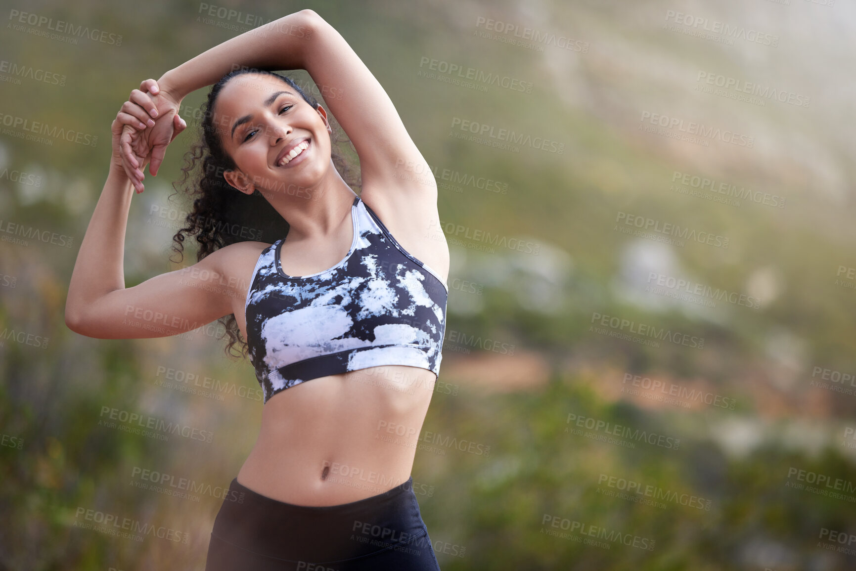 Buy stock photo Shot of a young woman stretching while out on a trail for a run