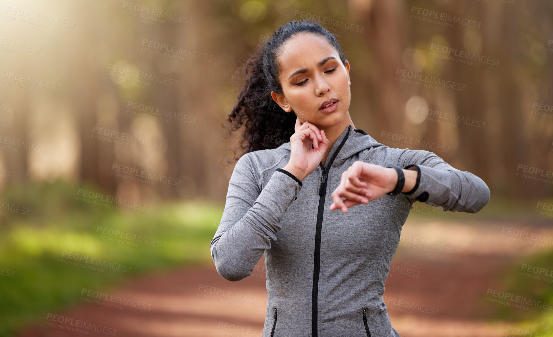 Buy stock photo Shot of a woman feeling her pulse while checking her watch