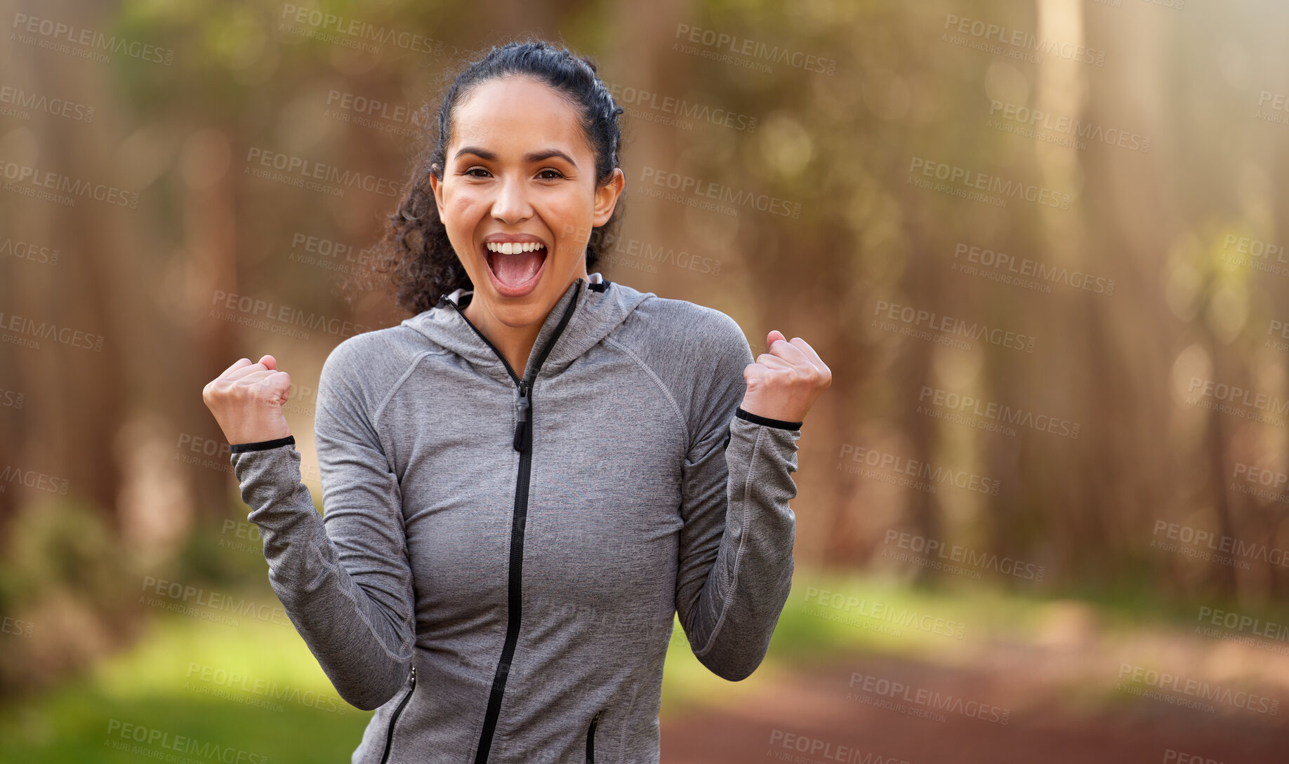 Buy stock photo Shot of a fit young woman looking cheerful while out for a run