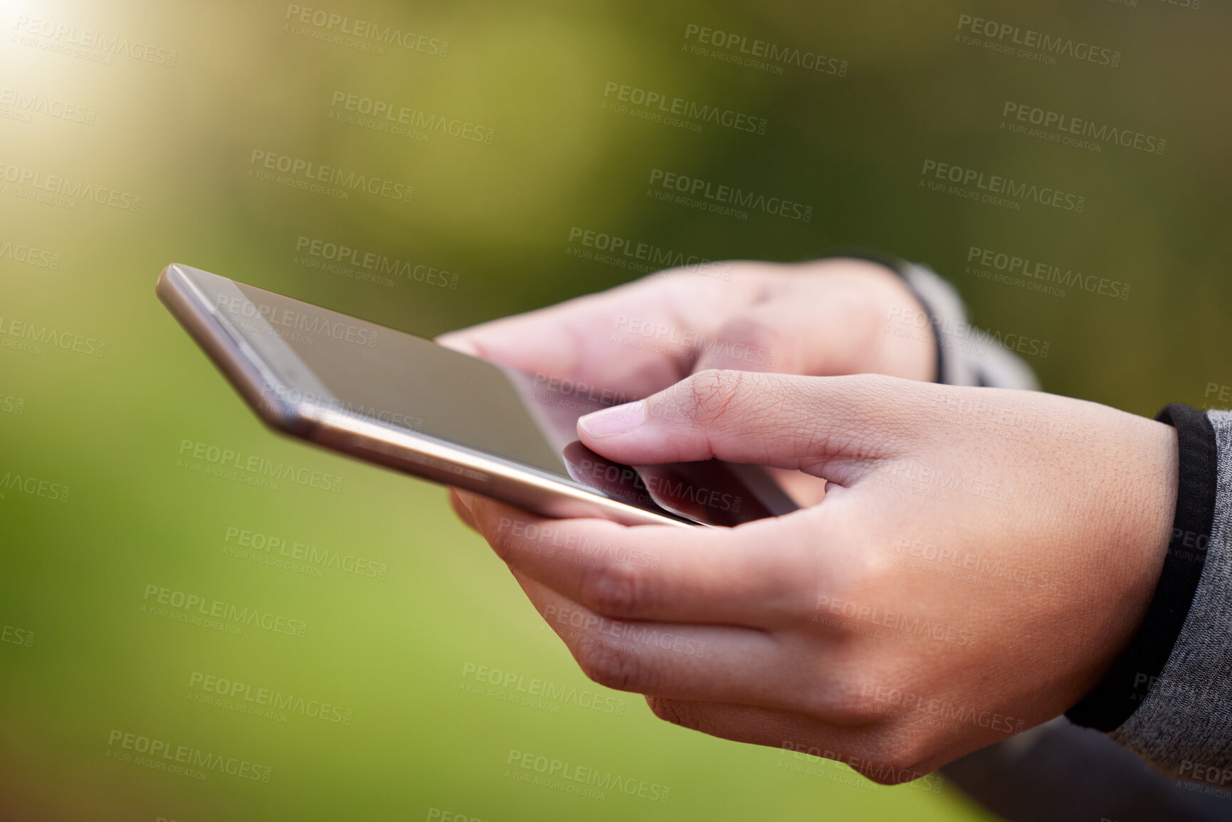 Buy stock photo Cropped shot of an unrecognizable woman using her cellphone while standing outside