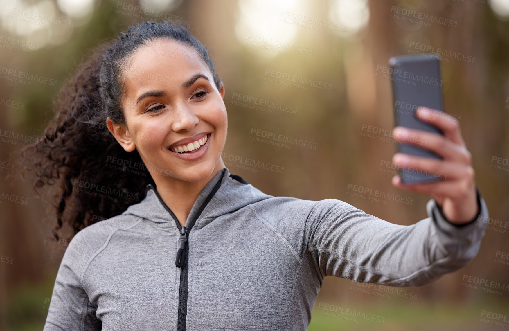 Buy stock photo Shot of a fit young woman taking a selfie while out for a run