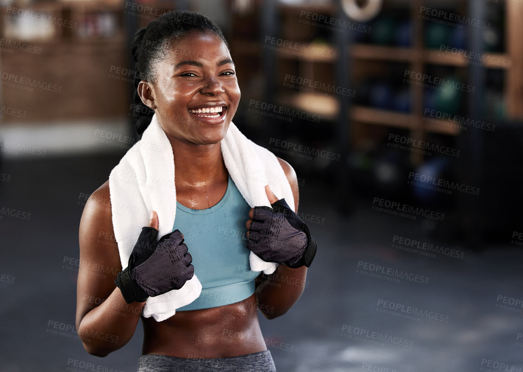Buy stock photo Shot of a sporty young woman posing with a towel around her neck at gym