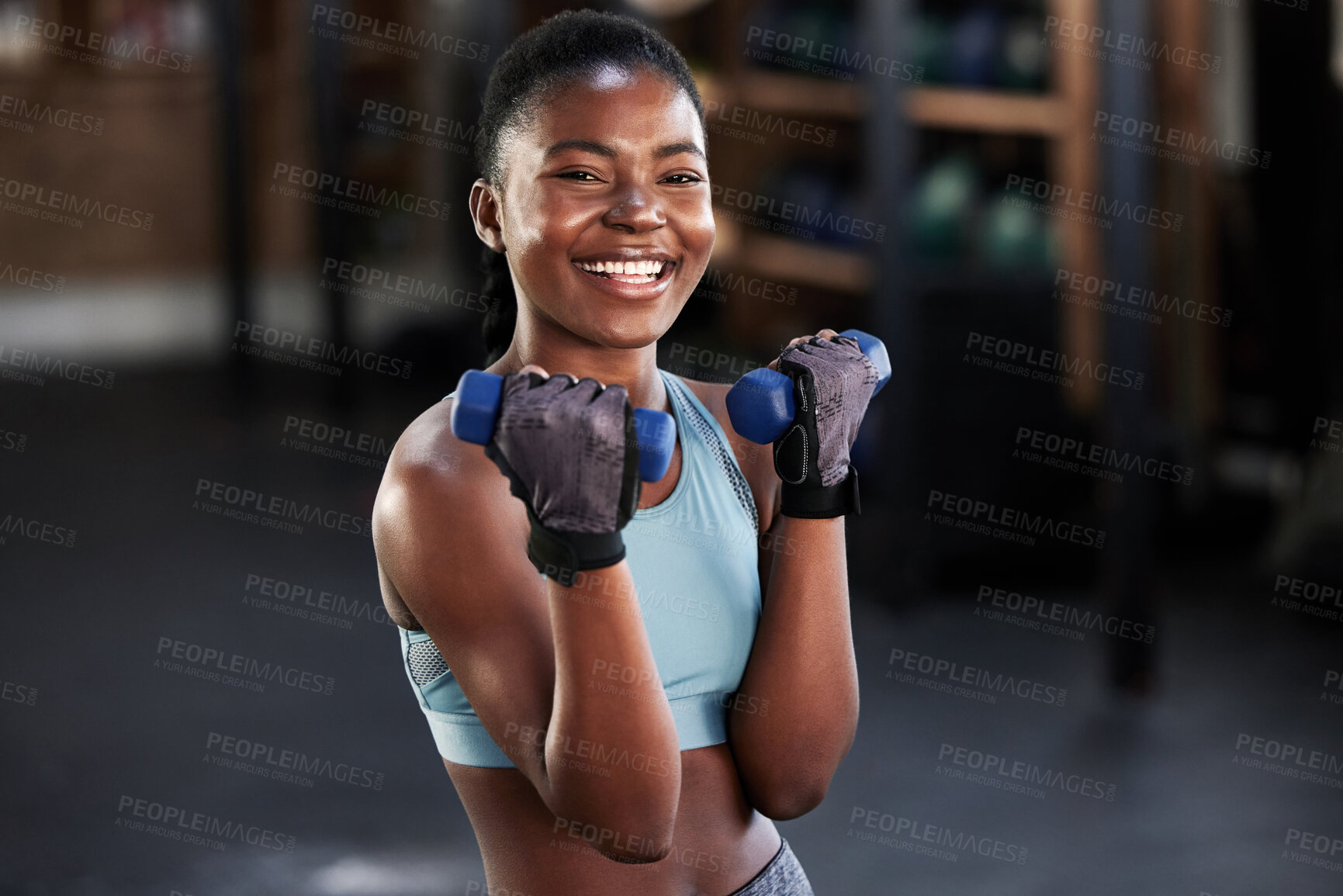 Buy stock photo Shot of a sporty young woman working out with dumbbells at the gym