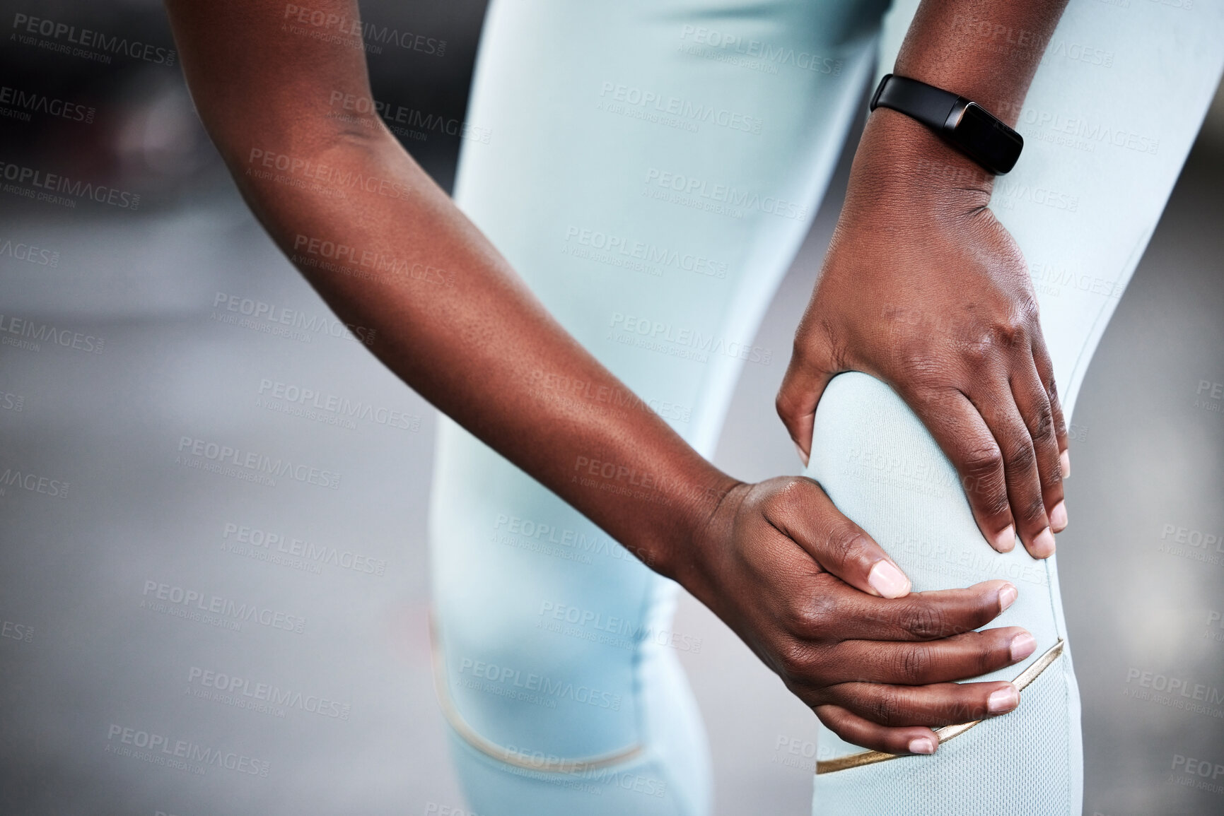 Buy stock photo Cropped shot of a young woman holding her knee in pain while at the gym