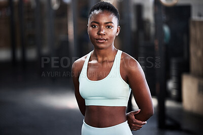 Buy stock photo Shot of a confident young woman standing alone in a gym