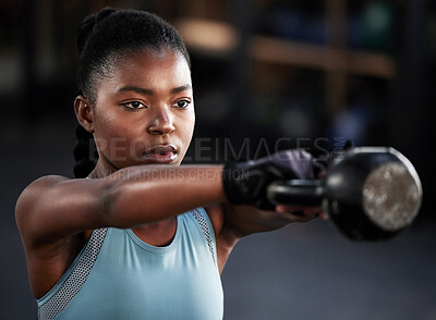 Buy stock photo Shot of a woman working out with a kettle bell at the gym