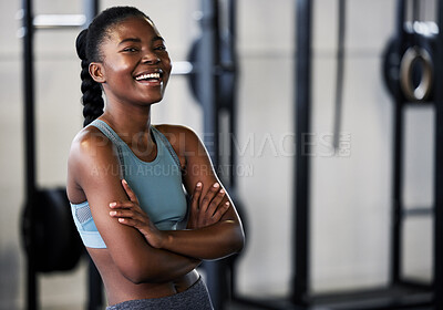 Buy stock photo Shot of a fit young woman posing with her arms crossed while standing alone in a gym