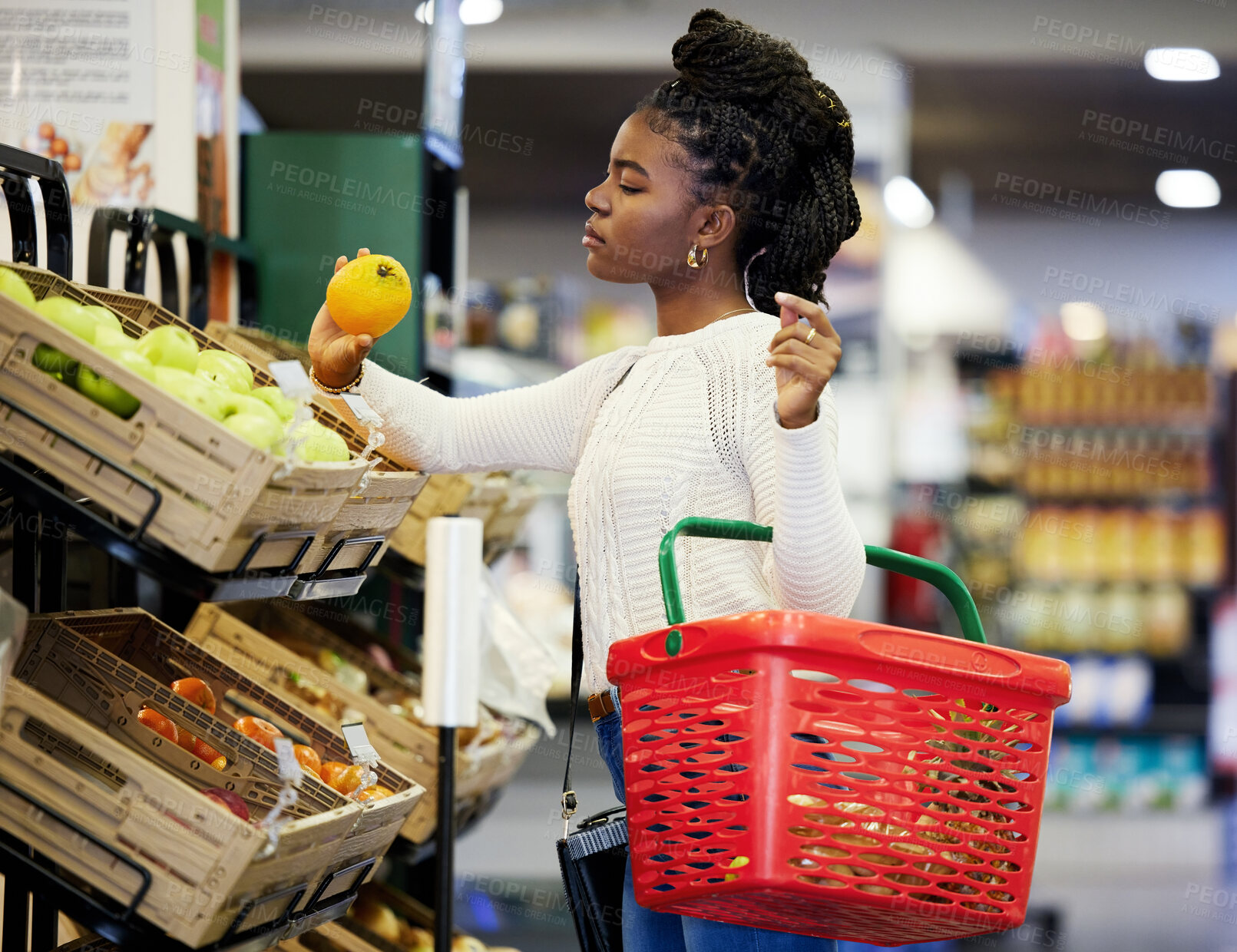 Buy stock photo Black woman, supermarket and shopping for grocery, vegetables and customer with healthy food in store basket. Person, retail shop and groceries, orange or buying fruit for vegan diet or nutrition