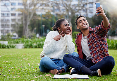 Buy stock photo Shot of a young man and woman taking selfies on a study break at college