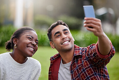 Buy stock photo Shot of a young man and woman taking selfies on a study break at college