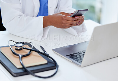 Buy stock photo Shot of an unrecognizable doctor using a phone and laptop at work