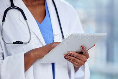 Buy stock photo Shot of an unrecognizable doctor using a digital tablet at work