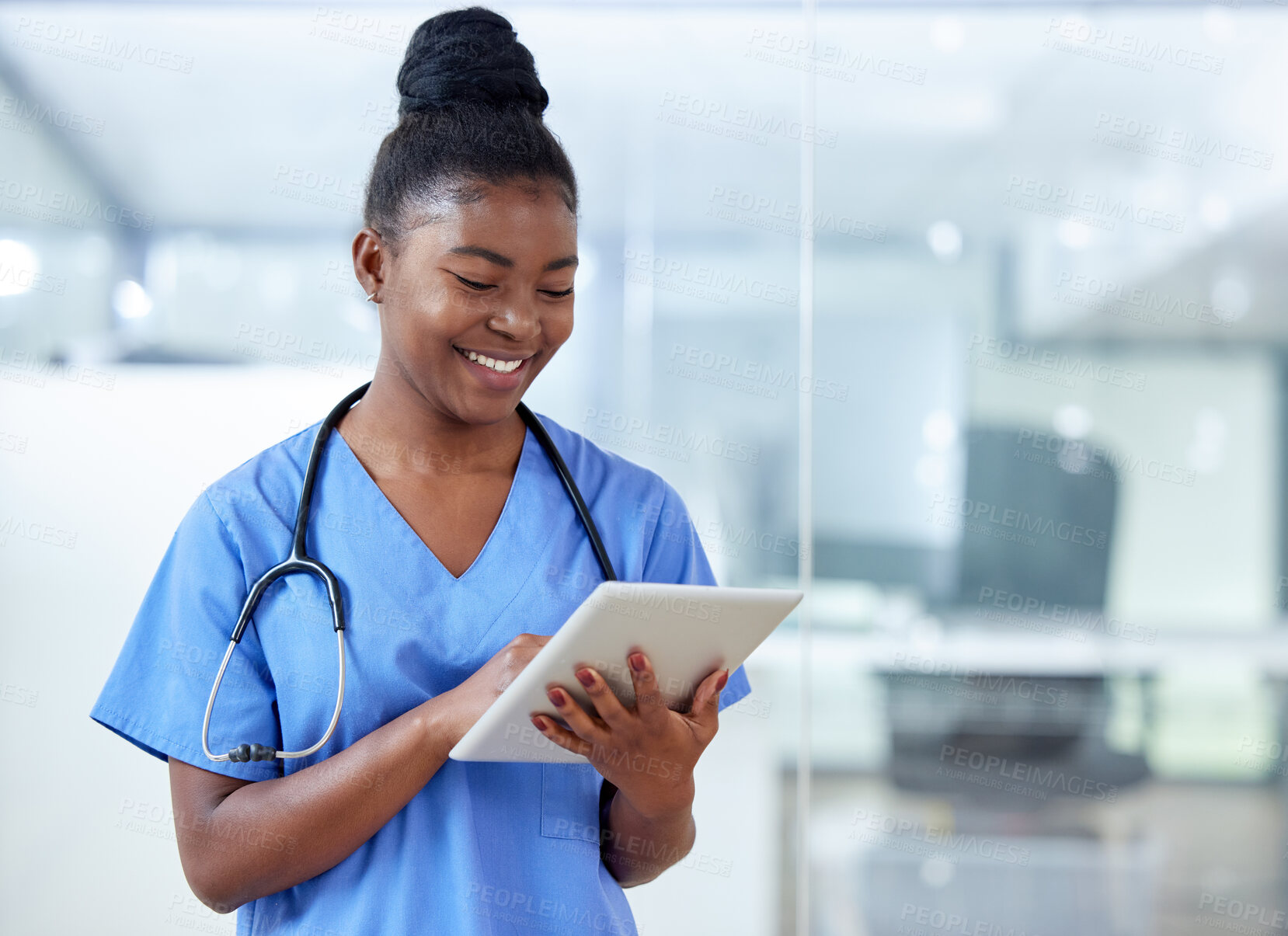 Buy stock photo Shot of a young female doctor using a digital tablet at work