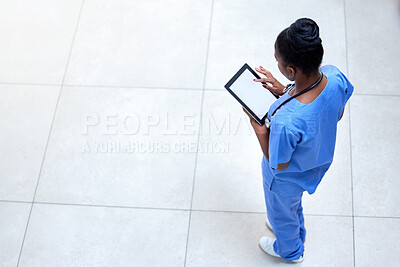Buy stock photo Shot of a young female doctor using a digital tablet at work