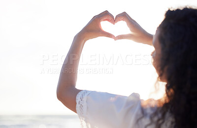 Buy stock photo Shot of an unrecognizable person making a heart gesture with their hands at the beach