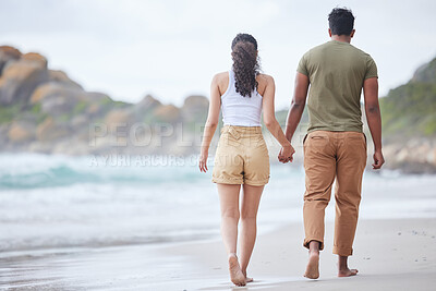 Buy stock photo Shot of an unrecognizable couple walking on the beach