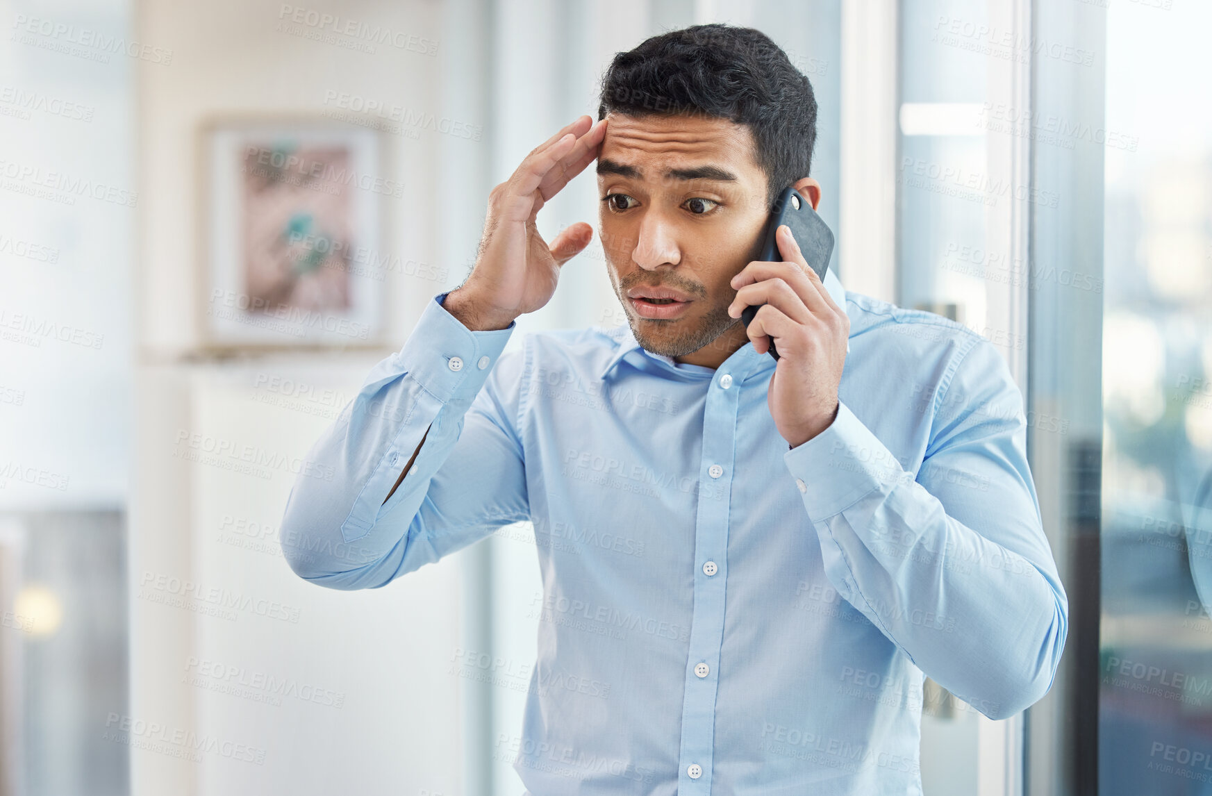 Buy stock photo Shot of a handsome young businessman making a phone call using his smartphone