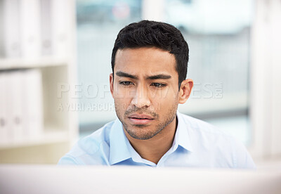 Buy stock photo Shot of a young businessman working at his desk