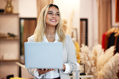 Buy stock photo Shot of a young business owner using a laptop in her clothing store