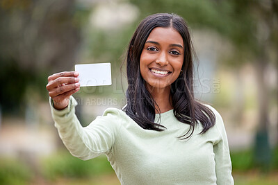 Buy stock photo Shot of a young woman holding a blank card outside at college