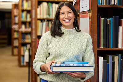 Buy stock photo Shot of a young woman holding books in a library
