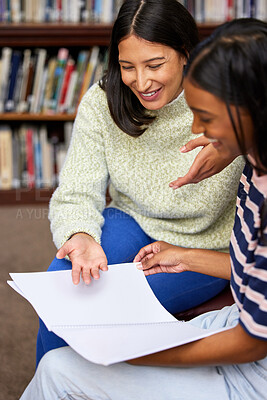Buy stock photo Shot of two young women having a discussion in a college library