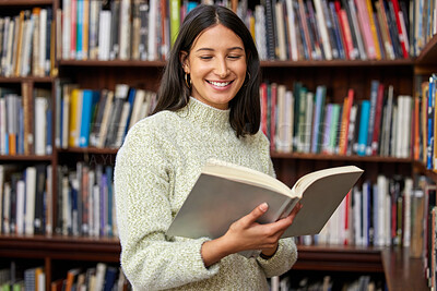 Buy stock photo Shot of a young woman reading a book in a library