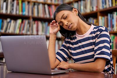 Buy stock photo Shot of a hispanic female using a laptop and being stressed in a library