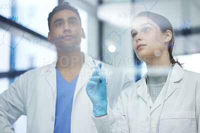Buy stock photo Shot of two scientists solving equations on a glass screen in a laboratory